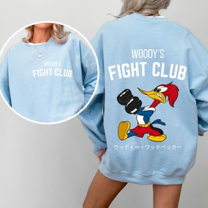 a woman wearing a sweatshirt with a cartoon character on it