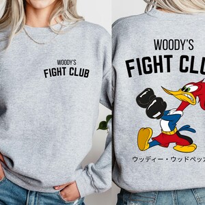 a woman wearing a sweatshirt that says woody's fight club