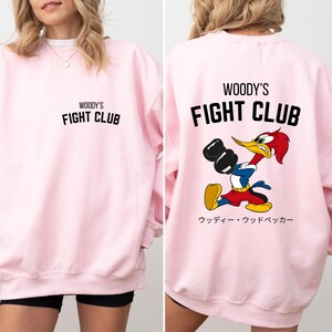 a woman wearing a pink sweatshirt and shorts