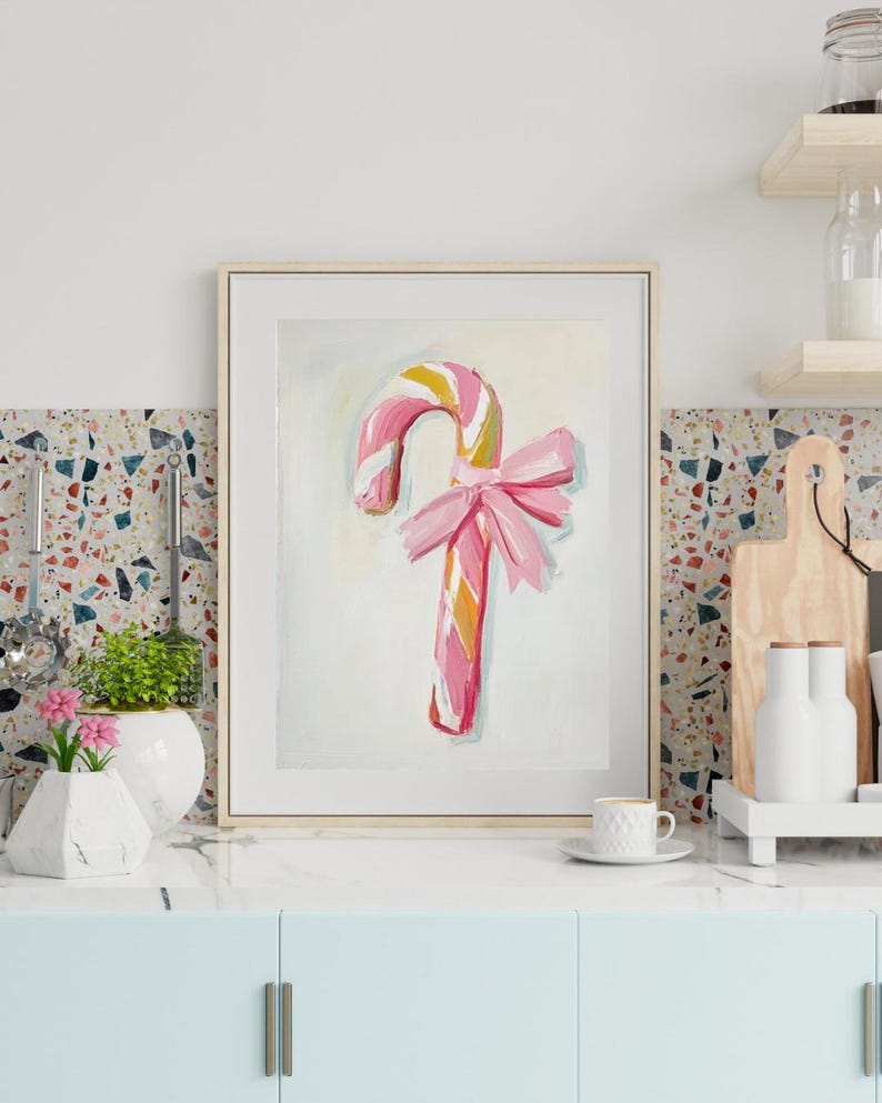 May include: A pink and white candy cane with a pink bow on a white background. The candy cane is painted in a whimsical style.