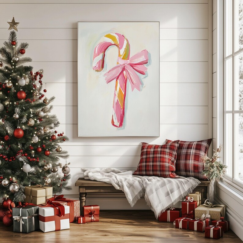 May include: A pink and white candy cane with a pink bow on a white background. The candy cane is painted in a whimsical style and is a festive Christmas decoration.