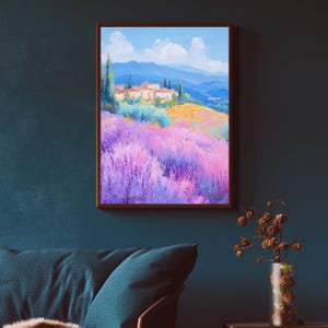 May include: A painting of a landscape with a small village in the distance. The village is surrounded by a field of purple flowers. The sky is blue with white clouds. The painting is framed in a brown frame.
