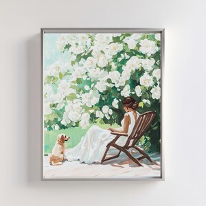 Può includere: Una donna con un vestito bianco è seduta su una sedia di legno in un giardino. È circondata da fiori bianchi e un piccolo cane è seduto accanto a lei.