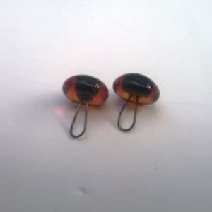 May include: Two brown and black glass eyes with a metal loop on the back. The eyes are for craft projects.
