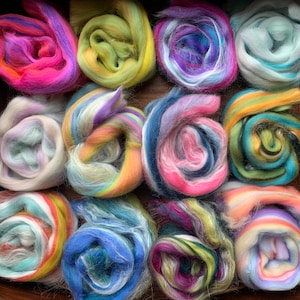 May include: A wooden box filled with 12 colourful rolls of wool yarn. The yarn is arranged in rows and is a variety of colours, including pink, blue, green, yellow, and purple.