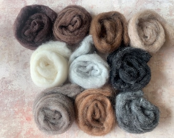 May include: Ten balls of wool yarn in various shades of brown, gray, and white. The yarn is arranged in a circle on a textured surface.