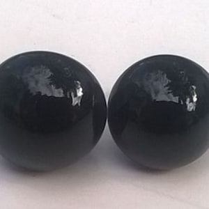 May include: A pair of black, round, glossy earrings.