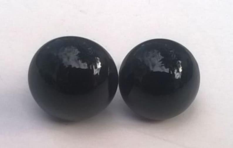 May include: A pair of black, round, glossy earrings.