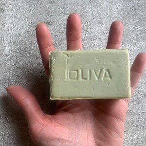 May include: A bar of green soap with the word "OLIVA" embossed on the front.