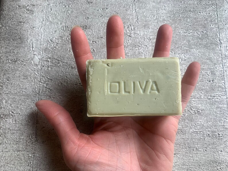 May include: A bar of green soap with the word "OLIVA" embossed on the front.