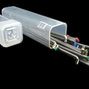 May include: A clear plastic case with a lid containing a set of metal tools with colored tips. The tools are arranged in a bundle and are visible through the clear case.