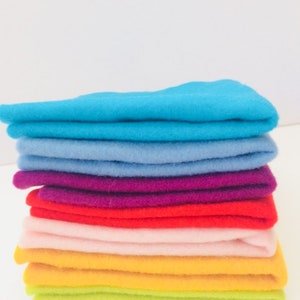 May include: A stack of felt fabric squares in various colors, including turquoise, light blue, purple, red, pink, yellow, and lime green.