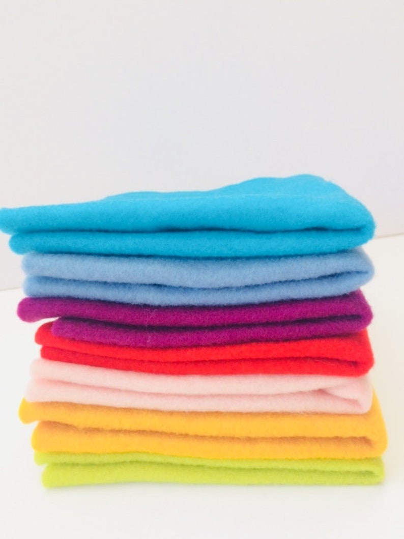 May include: A stack of felt fabric squares in various colors, including turquoise, light blue, purple, red, pink, yellow, and lime green.