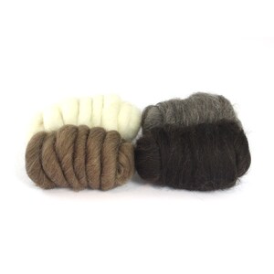 May include: Three skeins of wool yarn in different shades of brown. The skeins are arranged in a row, with the lightest shade on the left and the darkest shade on the right.