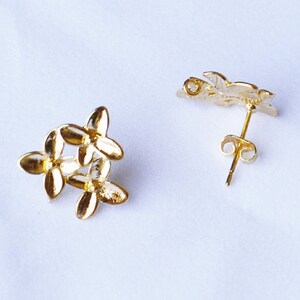 以下が含まれることがあります： 金色の花の形をしたスタッドピアスのペア。ピアスは金属製で、シンプルなデザインです。