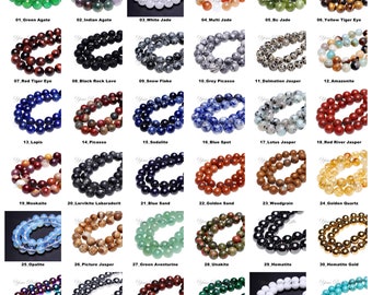 Könnte beinhalten: Eine Sammlung von 36 verschiedenen Arten von Edelsteinperlen, jede in einer Reihe von 10 Perlen dargestellt. Die Perlen sind alle rund und glatt und in verschiedenen Farben erhältlich, darunter Grün, Blau, Rot, Gelb, Braun, Schwarz, Weiß und Grau.