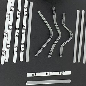 以下が含まれることがあります： 顔面マスク用の銀色の金属製ノーズワイヤーストリップのコレクション。ストリップは、ストレート、カーブ、角度など、さまざまな形状とサイズがあります。ストリップには、数字と文字がラベル付けされています。