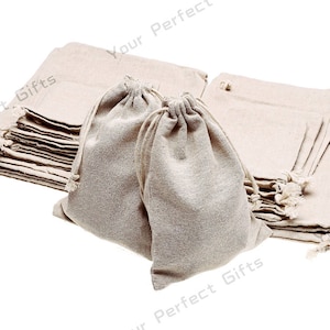 May include: A stack of 12 natural linen drawstring bags. The bags are made of a soft, natural fabric and are perfect for packaging small gifts or favors.