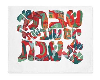Könnte beinhalten: Ein rechteckiges weißes Platzset mit hebräischem Text in einer fetten, stilisierten Schriftart. Die Buchstaben sind mit einem lebendigen, abstrakten Muster aus wirbelnden Rot-, Blaugrün-, Orange- und Hellgrüntönen gefüllt, was ein kontrastreiches Design ergibt.