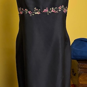 Puede incluir: Una taza de cerámica blanca con asa negra y el texto "But First, Coffee" en negro, con fuente de estilo manuscrito. La taza está sobre una superficie blanca.