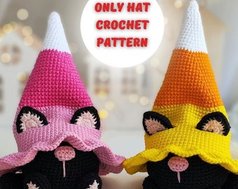 May include: Two crocheted black cat toys wearing candy corn hats. The hats are pink and white or yellow and orange. There are also four small crocheted candy corn toys.