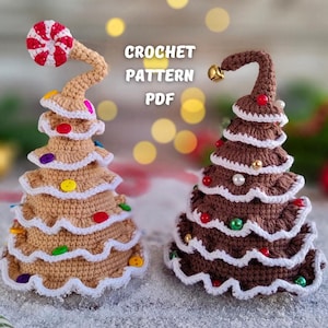 Könnte beinhalten: Zwei gehäkelte Lebkuchen-Weihnachtsbäume, einer braun und einer beige, mit bunten Süßigkeiten-Dekorationen. Die Bäume stehen auf einer weißen Oberfläche mit einem Zuckerstangen im Vordergrund. CROCHET PATTERN PDF