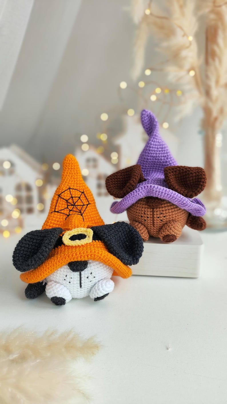 May include: Two crocheted Halloween dog toys. One is orange with a black spiderweb and black ears. The other is brown with purple ears and a purple hat.