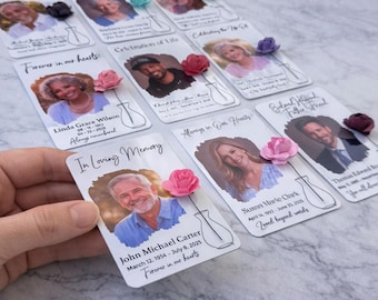 May include: Memorial cards with photos of loved ones, each adorned with a small paper flower and a vase illustration. The cards feature names, dates, and phrases like "Forever in our hearts" and "In Loving Memory."