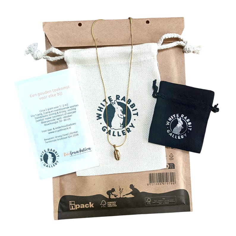 Eco friendly, gift ready packaging. Showing the coffee bean pendant on the snakeskin chain. Small black jewelry bag and larger white gift pouch. Also shwon the complimentary organic wildflower seed pack