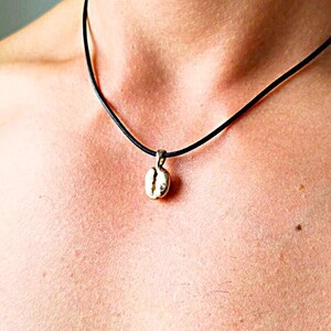 Gold plated cofee bean necklace. Shown on a male model and on a black wax cord