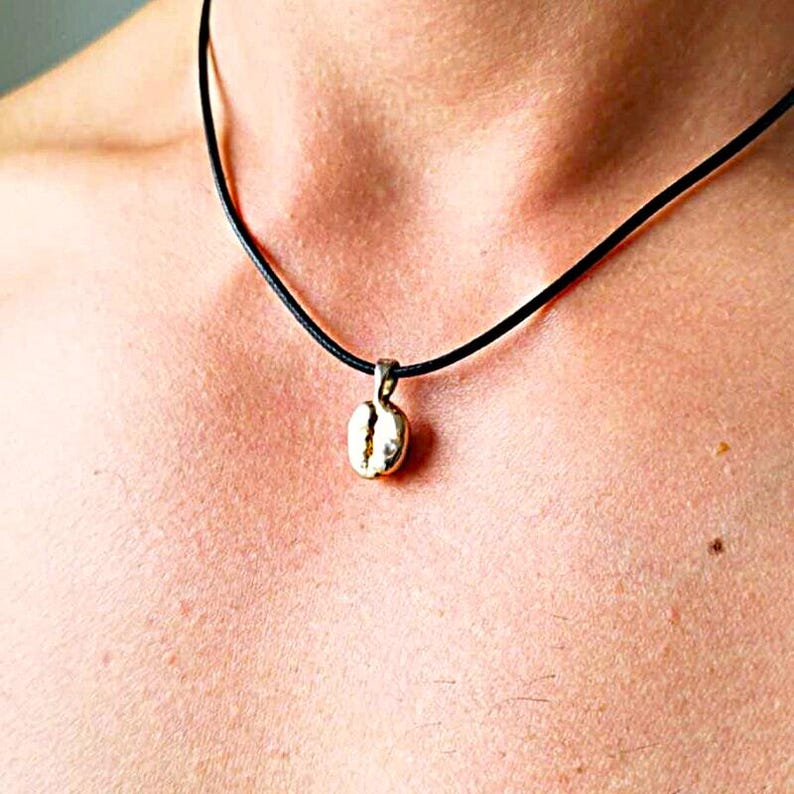 Gold plated cofee bean necklace. Shown on a male model and on a black wax cord