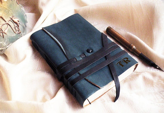 Handcrafted blue leather journal with custom monogram — the kind of travel companion that looks better with every scratch and adventure.