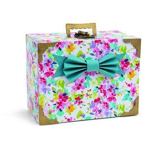 May include: A small floral patterned box with a teal bow and a gold handle. The box has a hinged lid and a lock.