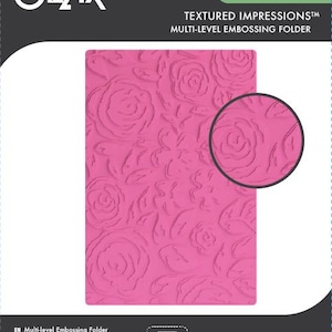 May include: A pink multi-level embossing folder with a rose pattern. The folder is labeled "Eileen Hull TEXTURED IMPRESSIONS" and "Sizzix". A circular close-up of the rose pattern is also shown.