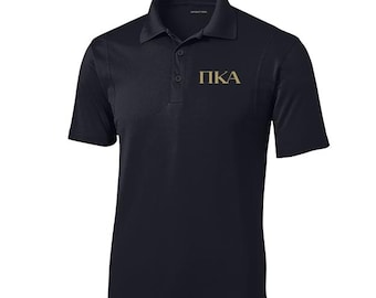 May include: A black polo shirt with a gold embroidered "PKA" logo on the left chest.