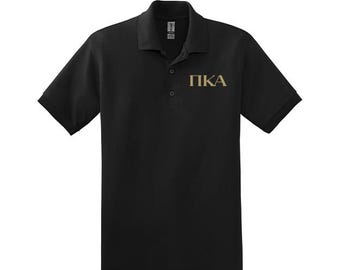 May include: Black polo shirt with a gold embroidered "PKA" on the left chest.