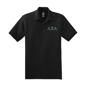May include: Black polo shirt with short sleeves and a collared neckline. The shirt features the letters "AXA" embroidered in a light green color on the upper left chest area. The shirt has a three-button placket.