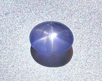 May include: A light blue star sapphire gemstone with a six-pointed star in the center.