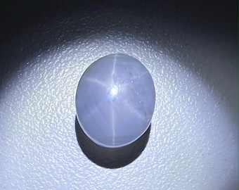 Könnte beinhalten: Ein runder, hellblauer Stern-Saphir-Edelstein mit einem sechszackigen Stern in der Mitte.