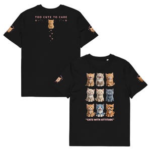 Puede incluir: Camiseta negra con un diseño de gatitos con diversas expresiones. La camiseta tiene el texto "TOO CUTE TO CARE" en la parte delantera y "CATS WITH ATTITUDE" en la trasera. También hay gráficos de gatitos en las mangas.