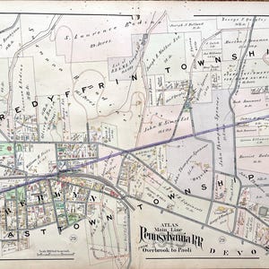 May include: A vintage map of the Main Line Pennsylvania Railroad from Overbrook to Paoli, showing the towns of Tredyffrin, Easttown, and Devon. The map is printed in black and white with colored lines and text.