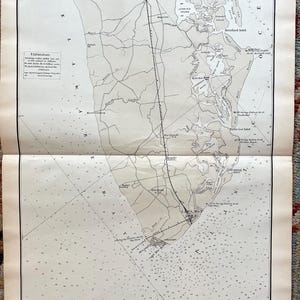 May include: Antique nautical map of the New Jersey coastline, featuring detailed depictions of bays, inlets, and coastal towns. The map is printed in shades of gray and black, with text labels and navigational markers. The map is folded in half.