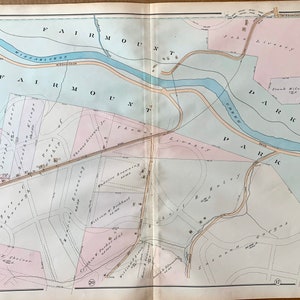 May include: A vintage map of part of Ward 21 in Fairmount Park, Philadelphia, Pennsylvania. The map shows the names of streets, parks, and property owners. The map is printed on a light blue background with pink and light blue accents.
