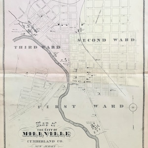 May include: A black and white map of Millville, New Jersey, showing the city's layout and streets. The map is divided into three wards: First, Second, and Third. The map also includes a compass rose and a scale bar.