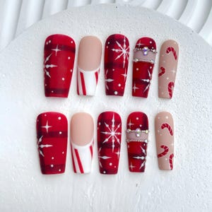 Uñas postizas navideñas con copos de nieve, estrellas y rayas festivas, uñas postizas rojas festivas / uñas elegantes en rojo y rosa