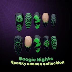 May include: A collection of ten black and green false nails with different designs. The designs include dice, spirals, a character face, and a spiderweb. The text "Boogie Nights Spooky season collection" is at the bottom.