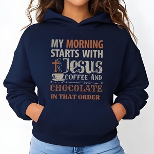 Peut inclure: Sweat &agrave; capuche bleu marine avec une poche avant et une capuche &agrave; cordon. Le devant du sweat &agrave; capuche affiche le texte "MY MORNING STARTS WITH JESUS COFFEE AND CHOCOLATE IN THAT ORDER" en plusieurs couleurs et polices.