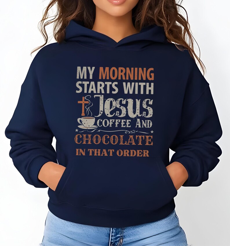 Peut inclure: Sweat &agrave; capuche bleu marine avec une poche avant et une capuche &agrave; cordon. Le devant du sweat &agrave; capuche affiche le texte "MY MORNING STARTS WITH JESUS COFFEE AND CHOCOLATE IN THAT ORDER" en plusieurs couleurs et polices.