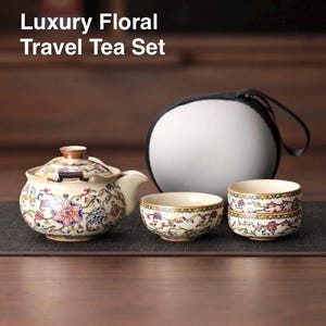 Puede incluir: Un juego de té de viaje floral color crema con una tetera, dos tazas y un estuche. La tetera y las tazas presentan un diseño floral colorido. El texto "Luxury Floral Travel Tea Set" está en la parte superior de la imagen.