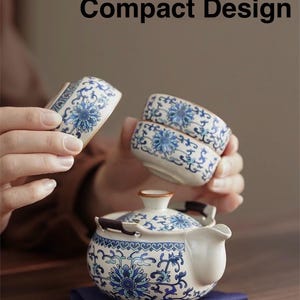 May include: A white ceramic tea set with blue floral patterns. The set includes a teapot, two small cups, and a rectangular piece. The text "All-in-one Compact Design" is displayed at the top of the image.